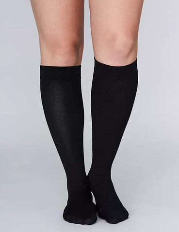 woman wearing black high medical compression socks 
