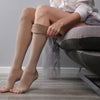 Woman's leg wearing beige color compression socks