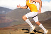 Man in white compression socks running for fitness and foot support.