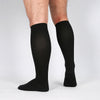 A man's leg standing wearing black color medical compression socks.